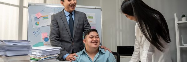 Asian young businessman patient work with manager in office workplace. Employee man special need worker brainstorm plan and discuss project with executive businessperson. Corporate of modern colleague